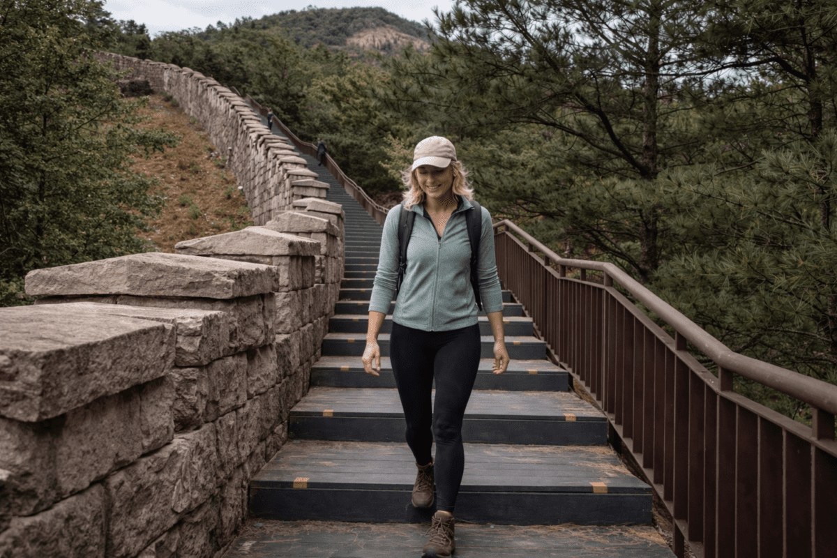Bugaksan trail — hiker descending Seoul fortress wall steps with city view