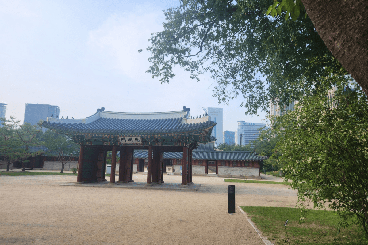five elements K-Saju rooted in Korean history — Gwangmyeongmun gate at Deoksugung Palace with Seoul skyline in the background