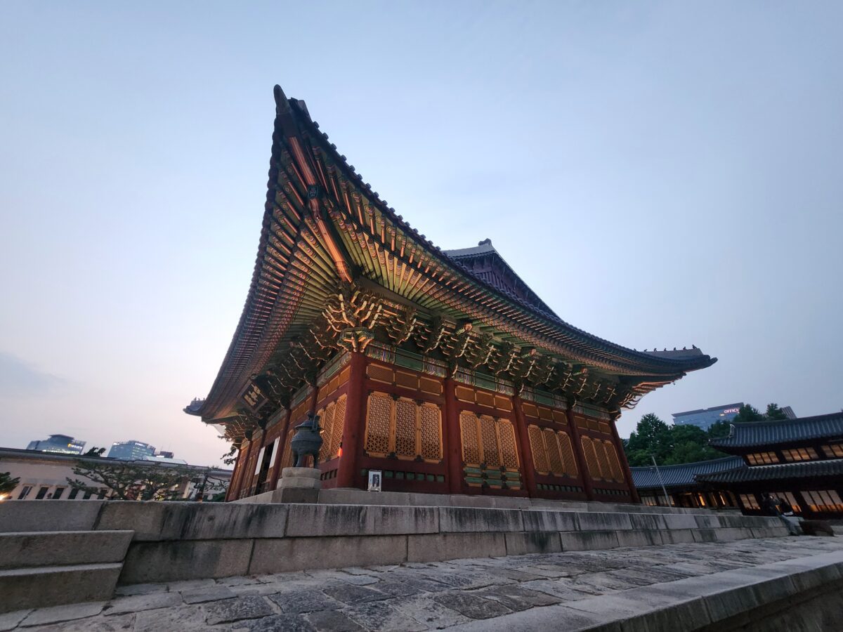 Gyeongbokgung Palace halls at dusk with misty hills in the background, Seoul

