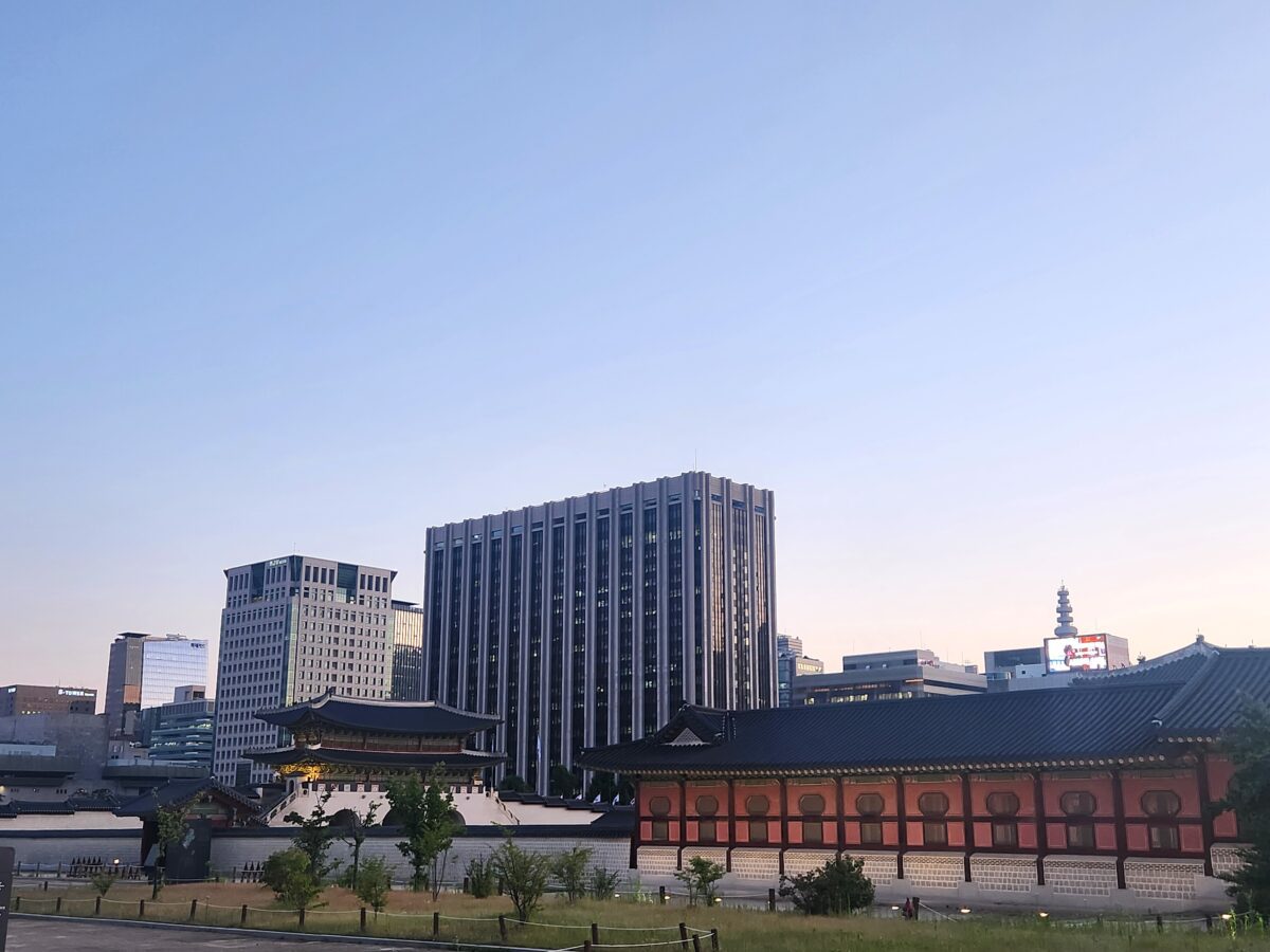 Bugaksan trail — hiker climbing Seoul fortress wall with Gwanghwamun Gate view