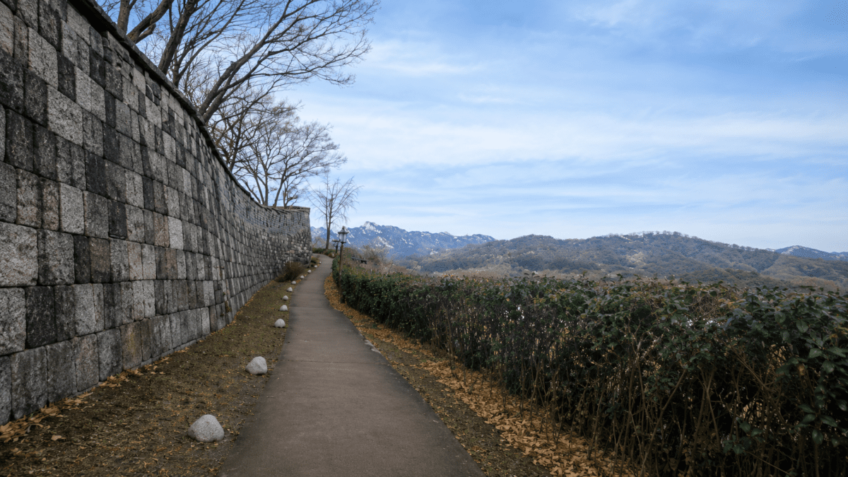korean timing system K-Saju — Hanyangdoseong fortress wall path in autumn, Seoul, photorealistic