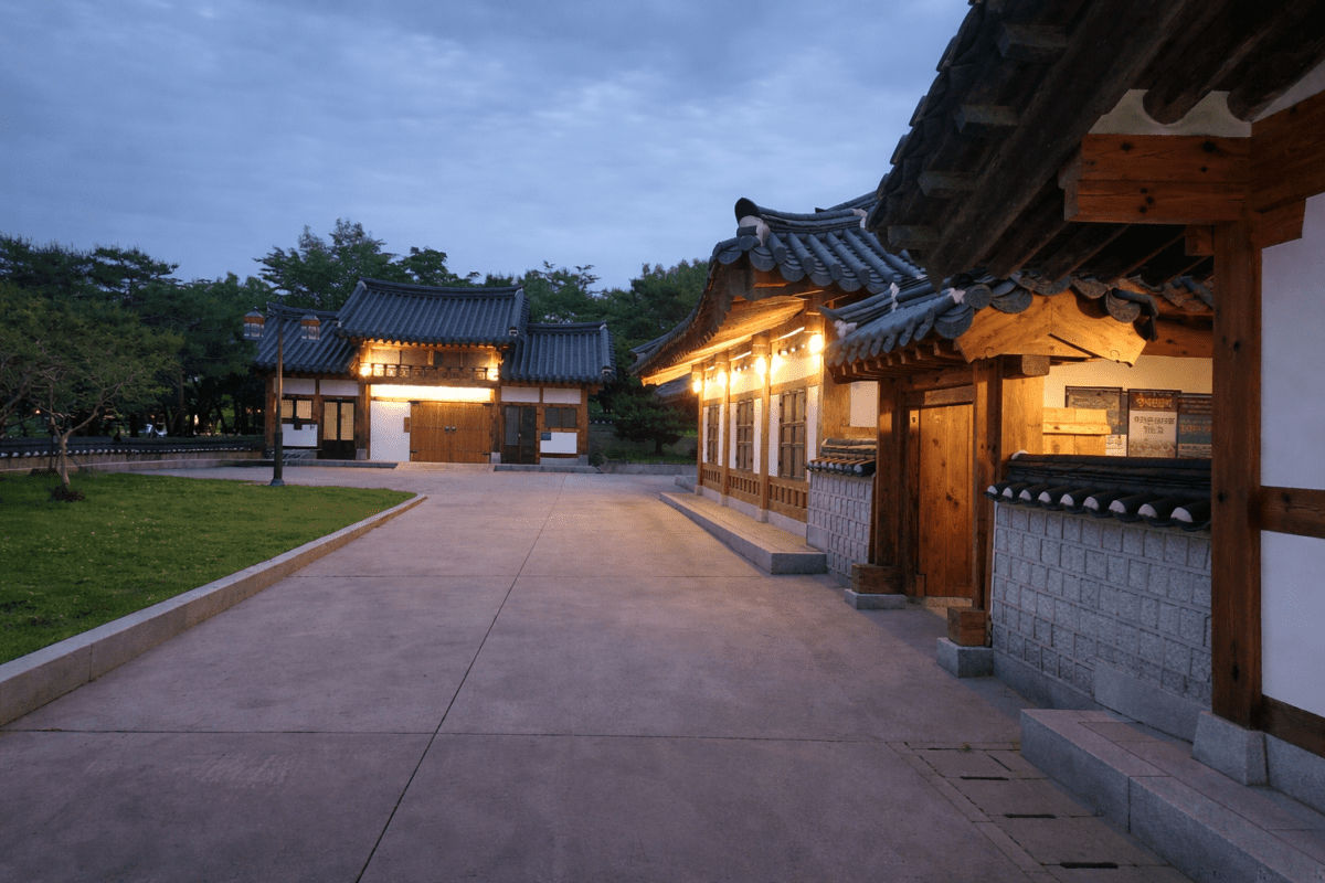 group chat anxiety — empty Korean traditional courtyard at dusk, warm lights, no one there