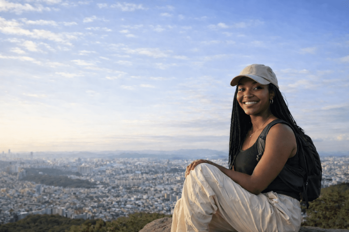 Gwanaksan hiking — hiker sitting on summit rock with Seoul city panorama below