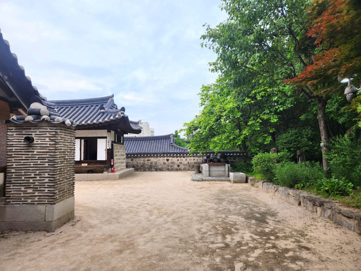Traditional Korean hanok courtyard with stone wall and jangdokdae pottery jars — Earth element K-Saju