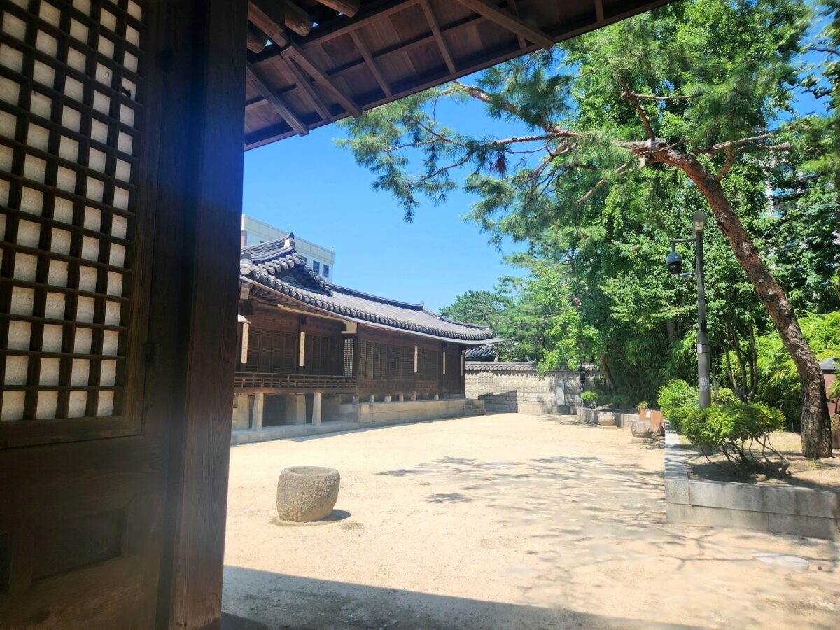 Korean hanok doorframe framing a courtyard — western astrology vs K-Saju two systems one person.