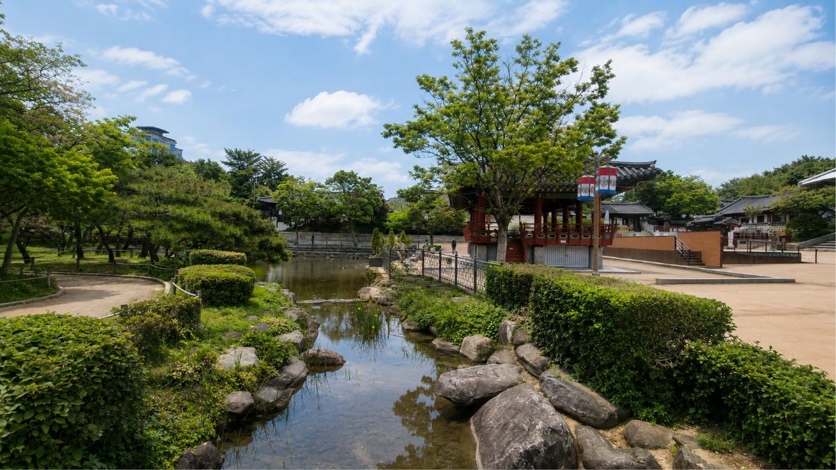 natal chart timing — Namsangol Hanok garden with stream and pavilion, the cycle that changes the ground you're on, Seoul