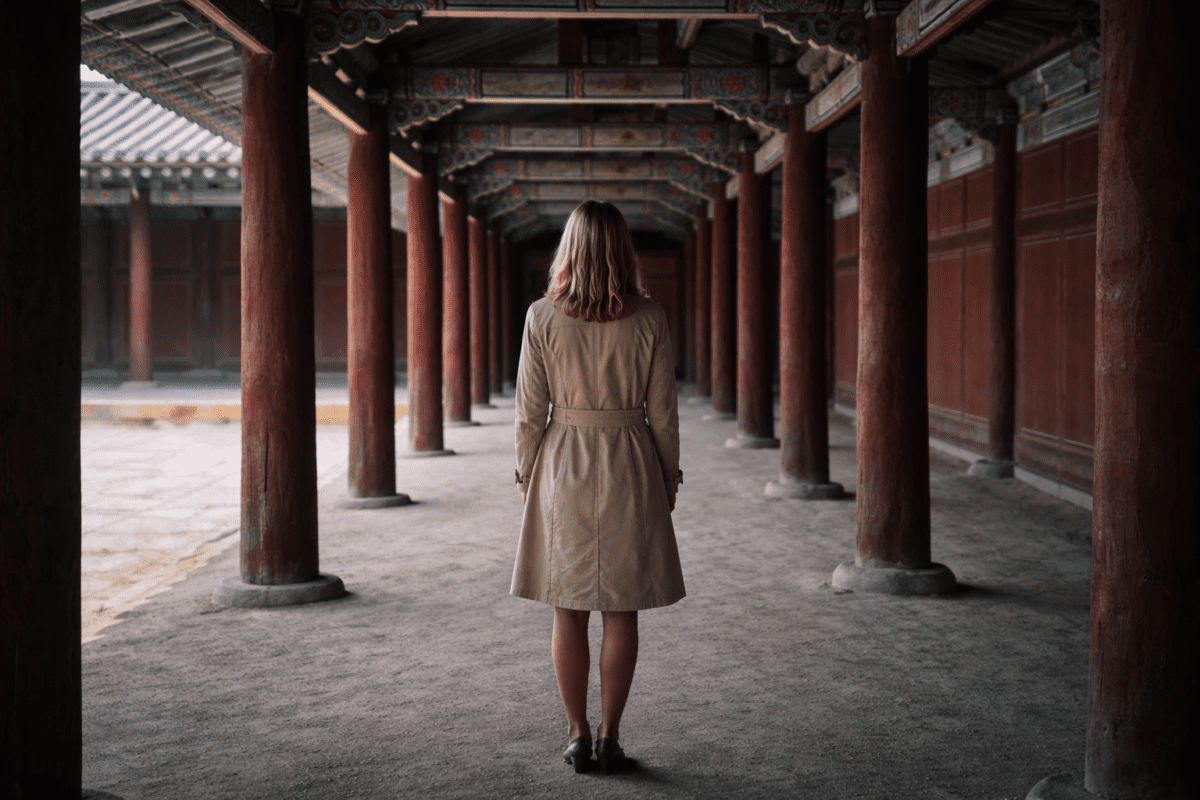 social withdrawal signs — woman walking alone through a Korean palace corridor, seen from behind