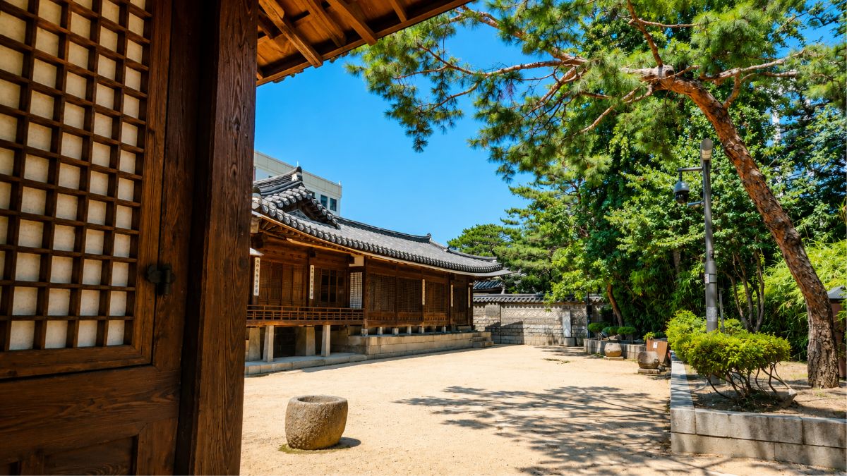 western astrology vs K-Saju — Hanok doorframe framing courtyard Seoul, using both systems without one canceling the other