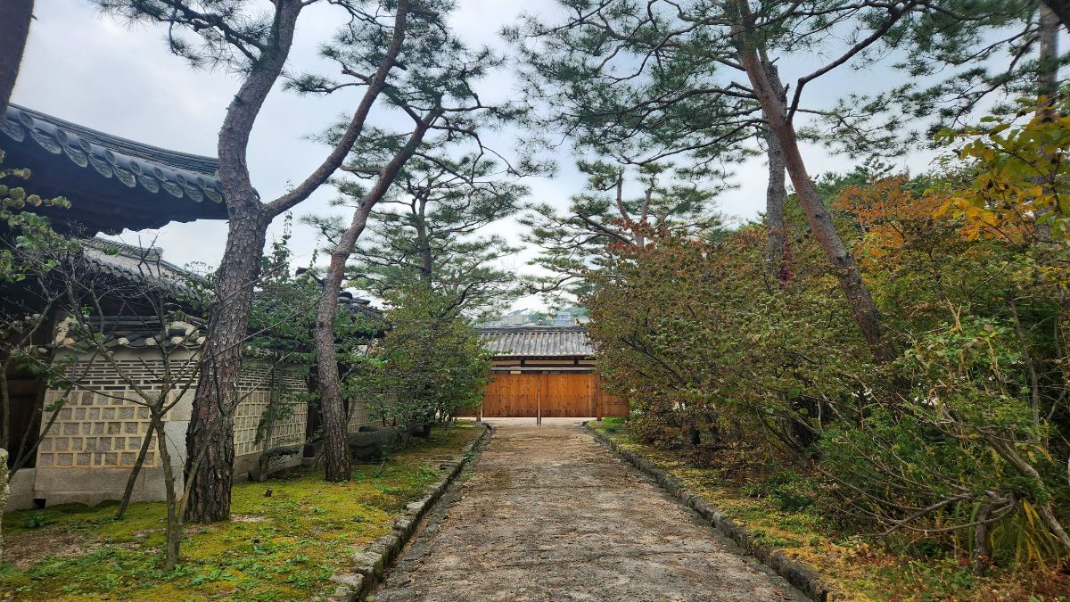 fear of being loved — stone path leading to closed wooden gate in Korean garden