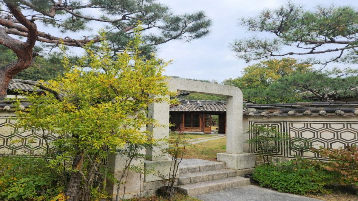 fear of intimacy — stone gate with steps leading into Korean garden courtyard with hanok building