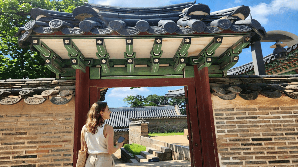 almost didn't pick up the phone — woman standing at hanok gate holding phone psychology