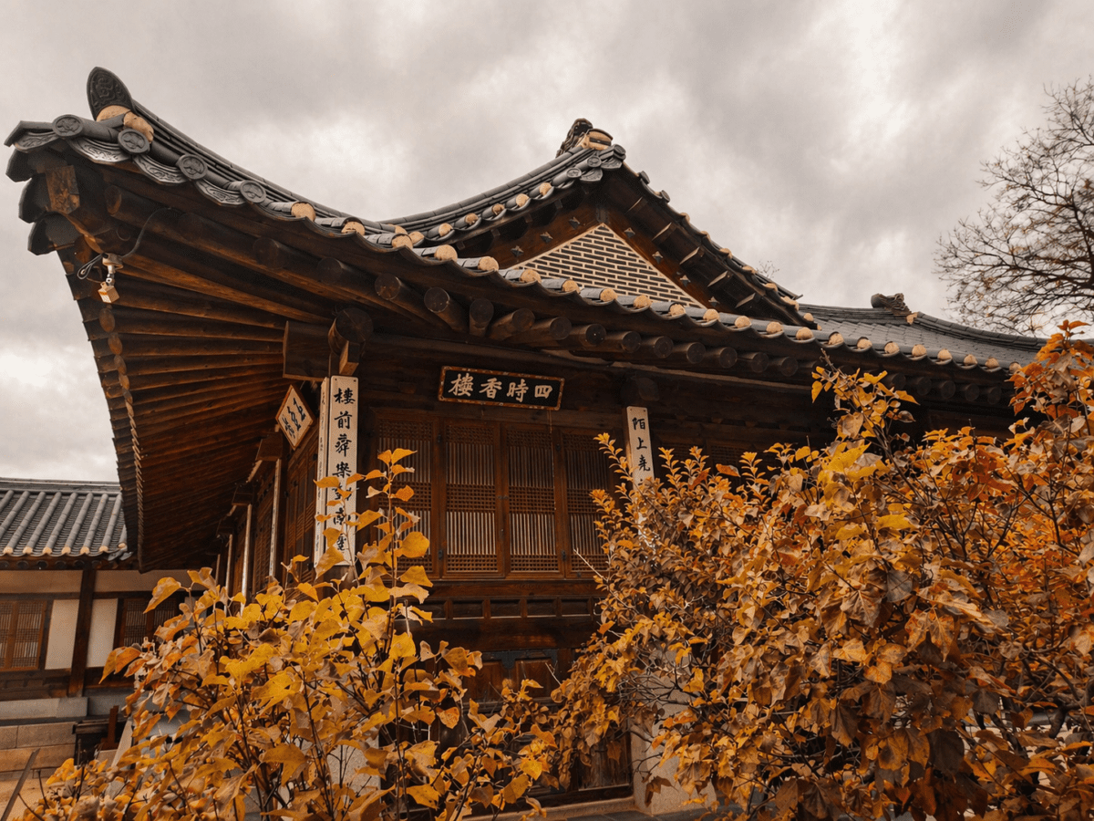 late autumn cycle astrology — a hanok hall with calligraphy plaques and yellow autumn foliage