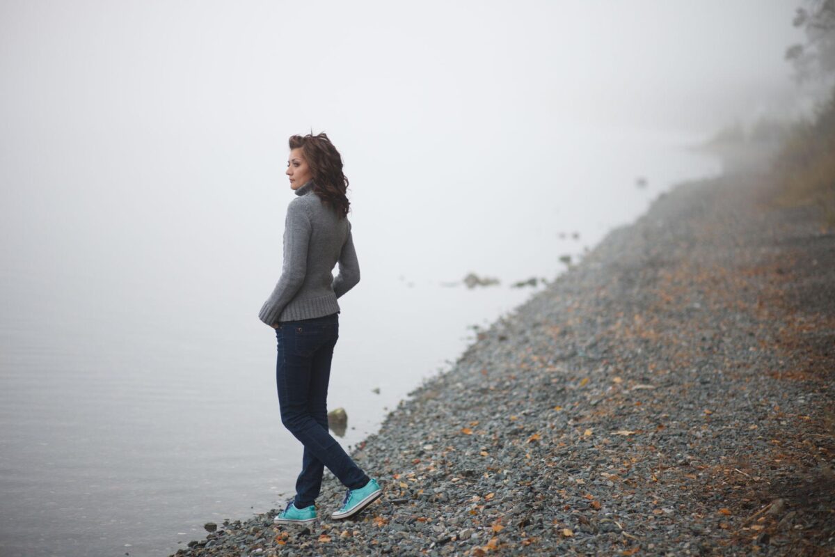 Woman running along misty lakeside moving forward after recognizing burnout as structural transition rather than seeking recovery