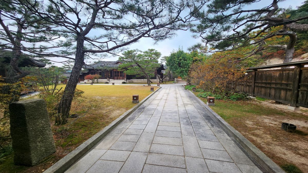 receiving love anxiety — open stone path through Korean garden leading toward hanok buildings