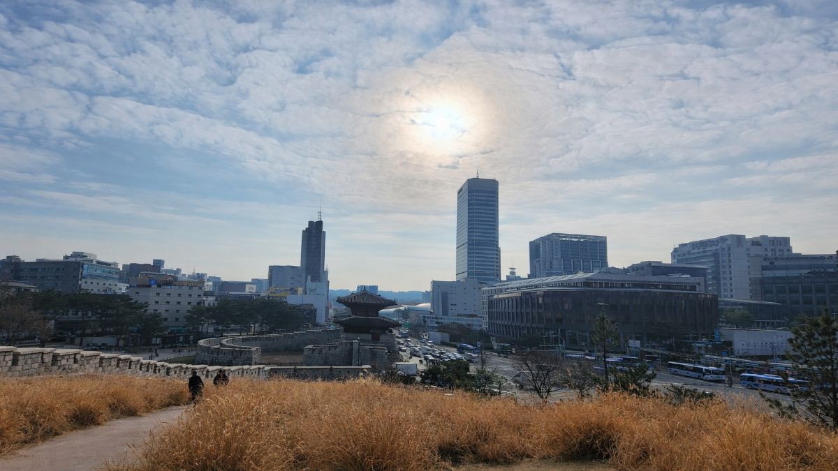 Seoul city wall and modern skyline, representing Korean men and makeup military culture
