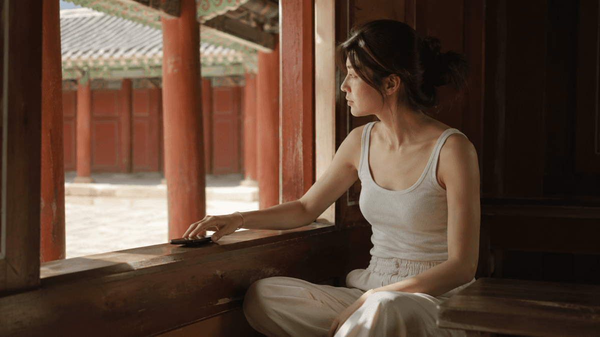 social withdrawal signs — woman setting her phone aside to look out at an empty corridor