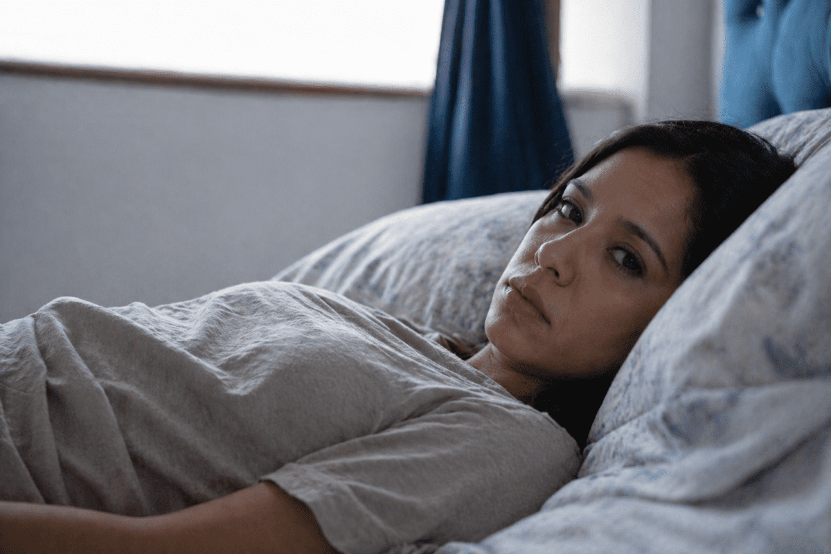 Woman stuck in the wrong major, lying in bed staring at ceiling, resignation and exhaustion visible