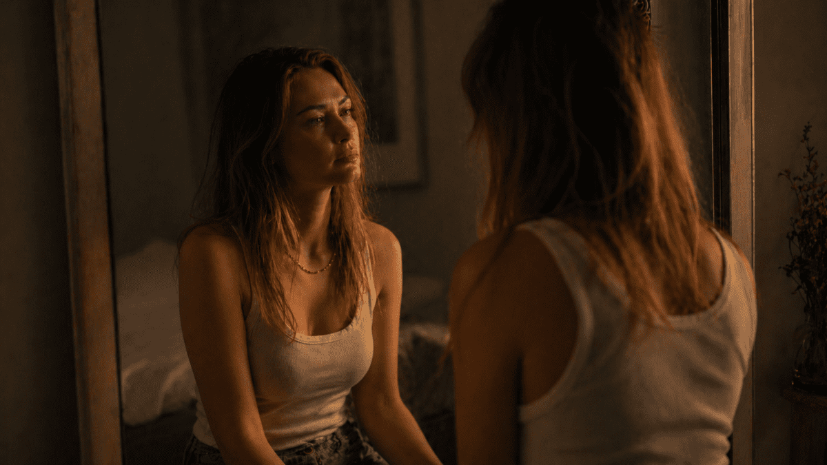 Trusting your own voice again — woman facing mirror with quiet recognition, moment of reconnection with herself, no longer silenced