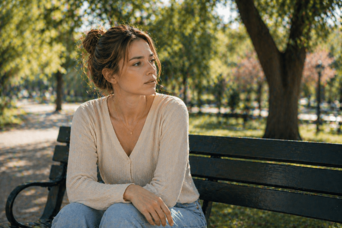 Two people remember completely differently — woman alone in park questioning which version is real, her memory against his certainty