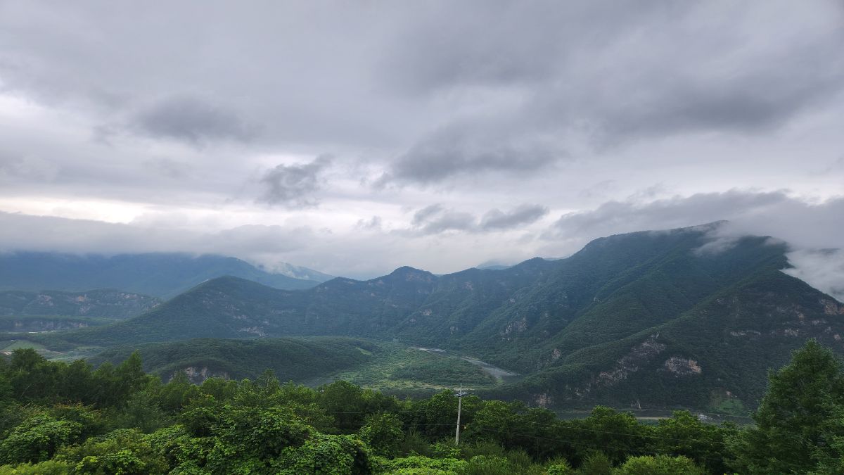 yang earth stem in K-Saju — layered Korean mountain valley under storm clouds