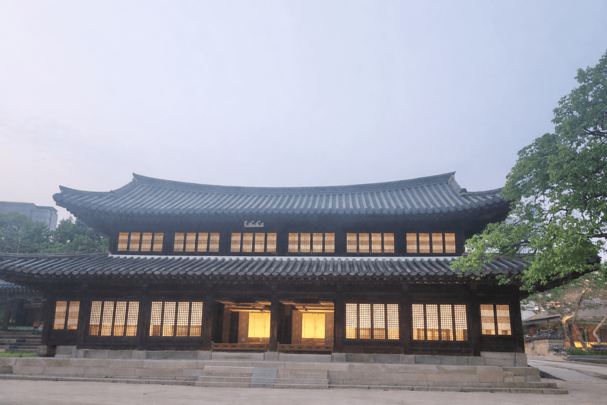 yin water stem in K-Saju — traditional Korean palace hall glowing from within at dusk under pale sky