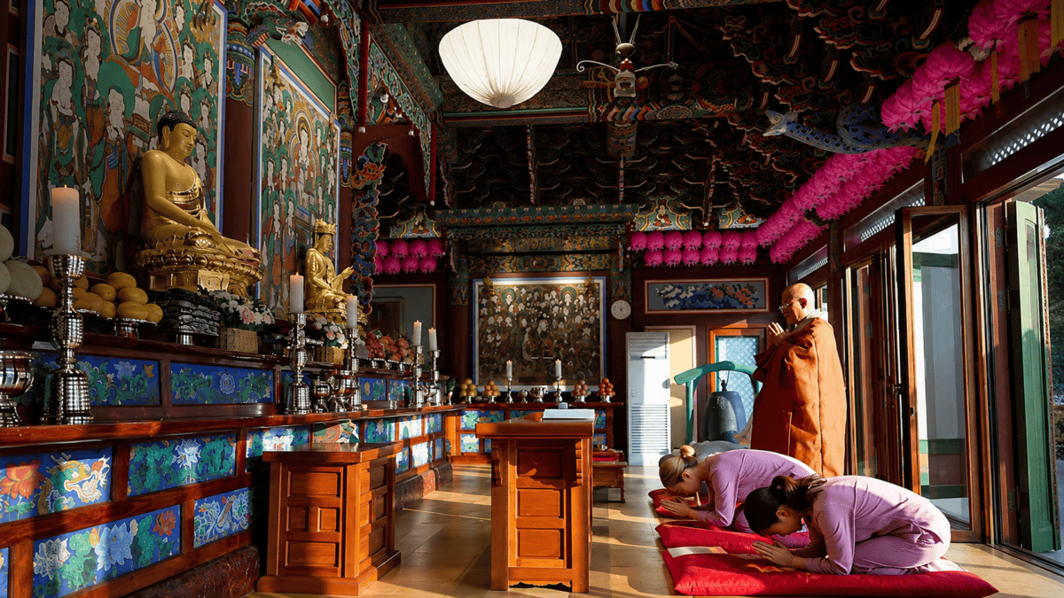 Korean temple experience participants paying respects inside the Main Buddha Hall at a traditional Korean Buddhist temple.