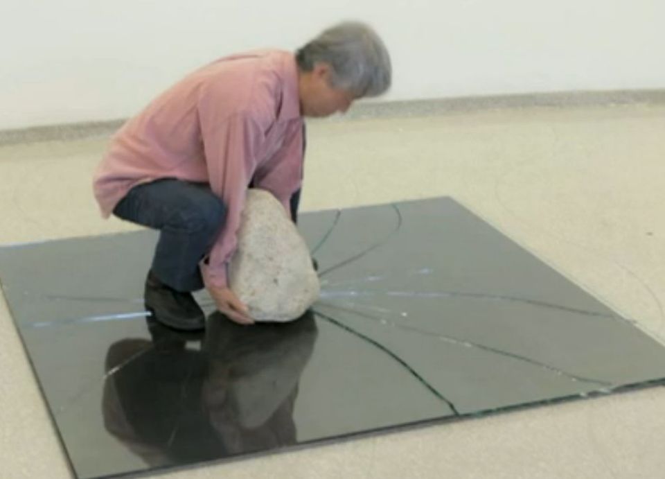 Lee Ufan silence performance placing a stone on broken glass as part of Relatum artwork