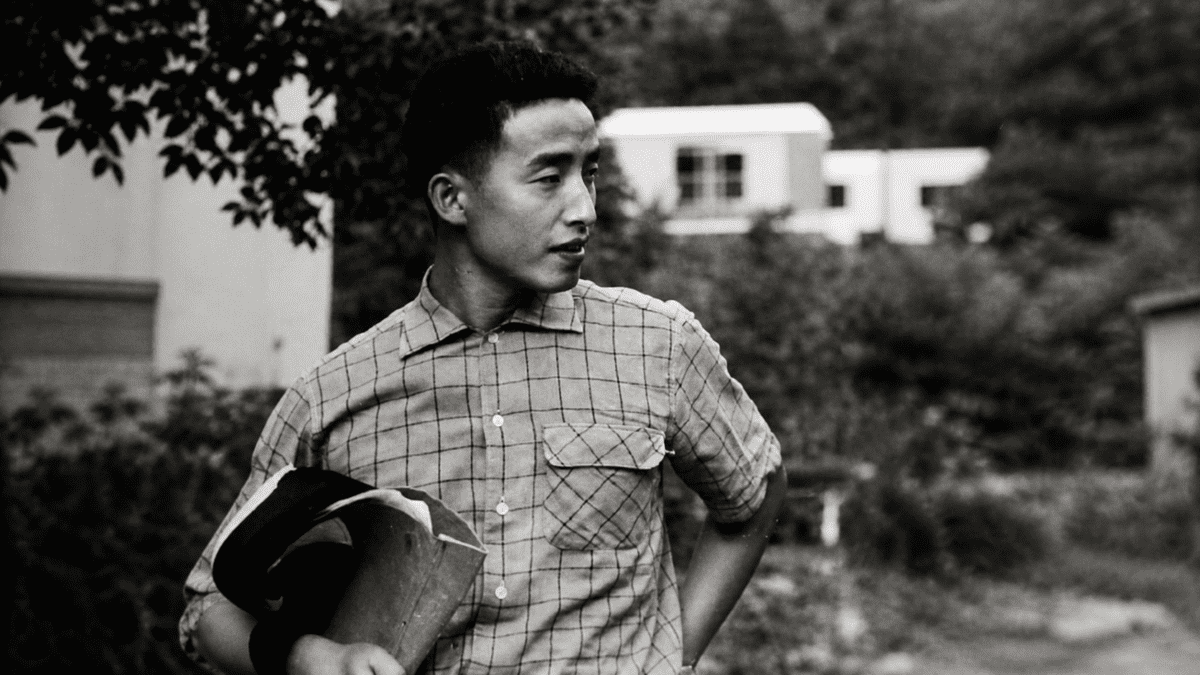 Young Nam June Paik standing outdoors during his early years before transforming media art