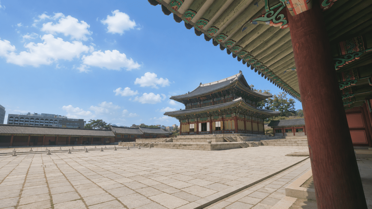 Korean palace courtyard under a clear sky with curved tiled roofs, anchoring the spring cycle meaning in astrology.