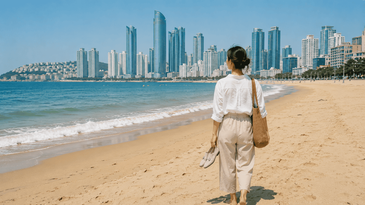 Woman walks barefoot on Haeundae Beach with her shoes in hand, waking up anxious and going anyway.